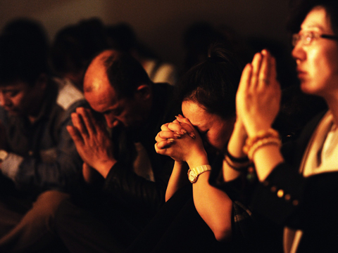 Angehörige der Passagiere des Flugs MH379 beten. 