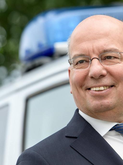 Der Bundesvorsitzende der Polizeigewerkschaft, Rainer Wendt, steht am 30.06.2016 vor einem Polizeibus in Köln.