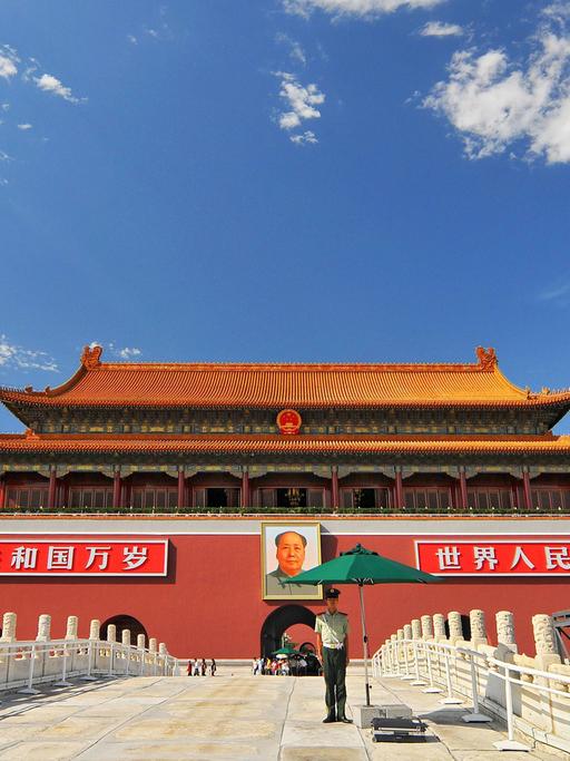 Der Eingang des Königspalasts und der Verbotenen Stadt auf dem Tiananmen-Platz in Peking mit einem Porträt von Mao Zedong und chinesischen Flaggen rechts und links