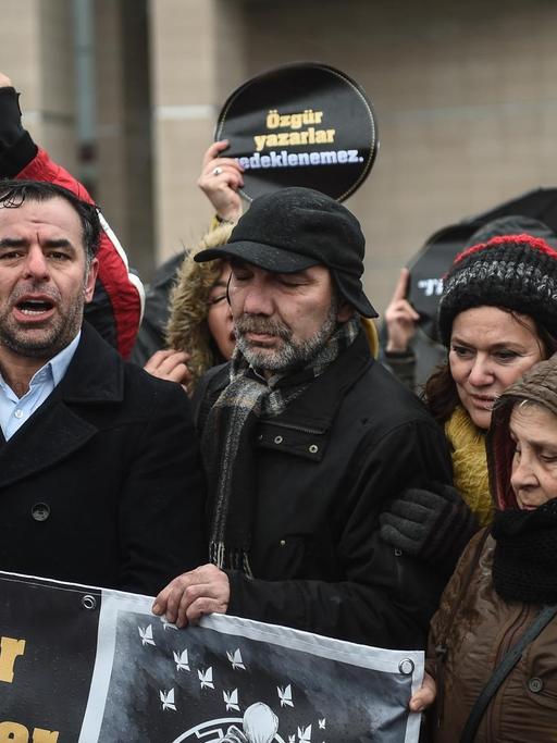 Türkische Oppositionspolitiker der Partei CHP stehen vor dem Istanbuler Gerichtsgebäude, um gegen eine Verurteilung der Autorin Asli Erdogan zu demonstrieren. Auf einem Banner steht in türkischer Sprache: "Wir werden kein Teil dieser Schande sein"