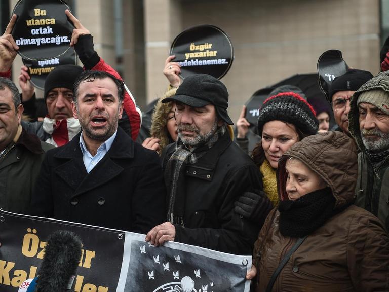 Türkische Oppositionspolitiker der Partei CHP stehen vor dem Istanbuler Gerichtsgebäude, um gegen eine Verurteilung der Autorin Asli Erdogan zu demonstrieren. Auf einem Banner steht in türkischer Sprache: "Wir werden kein Teil dieser Schande sein"