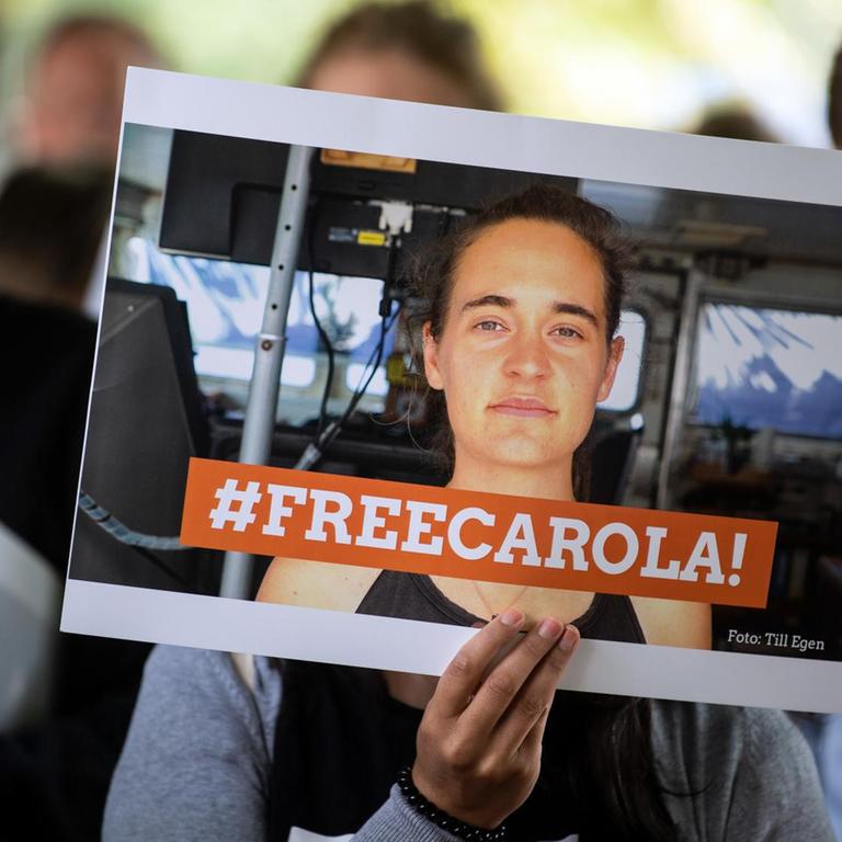 Eine Demonstrantin hält ein Bild von der Sea-Watch-Kapitänin Carola Rackete mit der Aufschrift "#FREECAROLA!" in der Hand. 