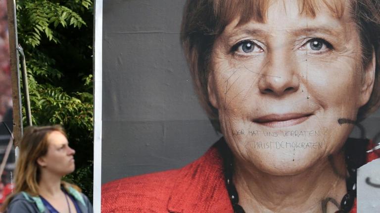 Eine Frau geht in Rostock vor zwei Wahlplakaten mit den Spitzenkandidaten von CDU und SPD entlang. Eine Frau geht in Rostock vor zwei Wahlplakaten mit den Spitzenkandidaten von CDU und SPD entlang.