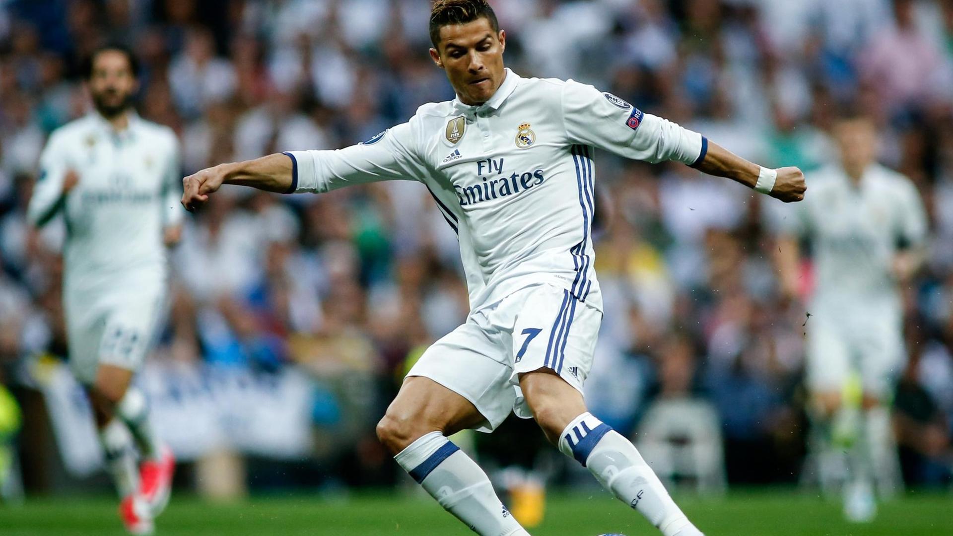 Cristiano Ronaldo nimmt auf em Rasen in Madrid eine Ball an.