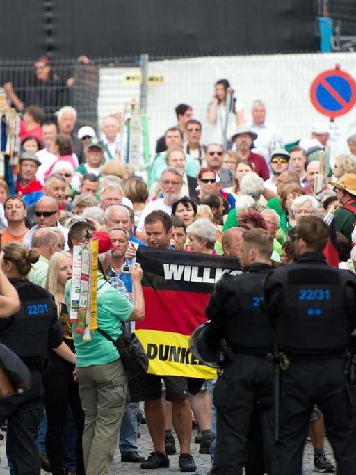 Mit Deutschlandfahnen und Transparenten protestieren am 26.06.2016 Menschen gegen den Besuch von Bundespräseident Gauck