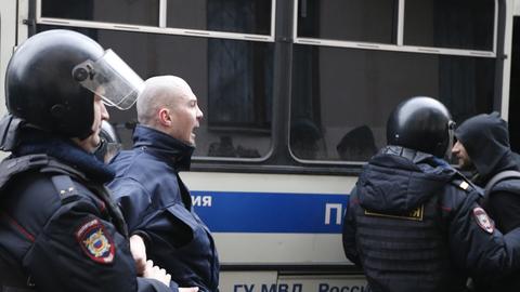 Russische Polizisten führen am 24. 2. 2014 vor einem Moskauer Gericht Demonstranten ab.