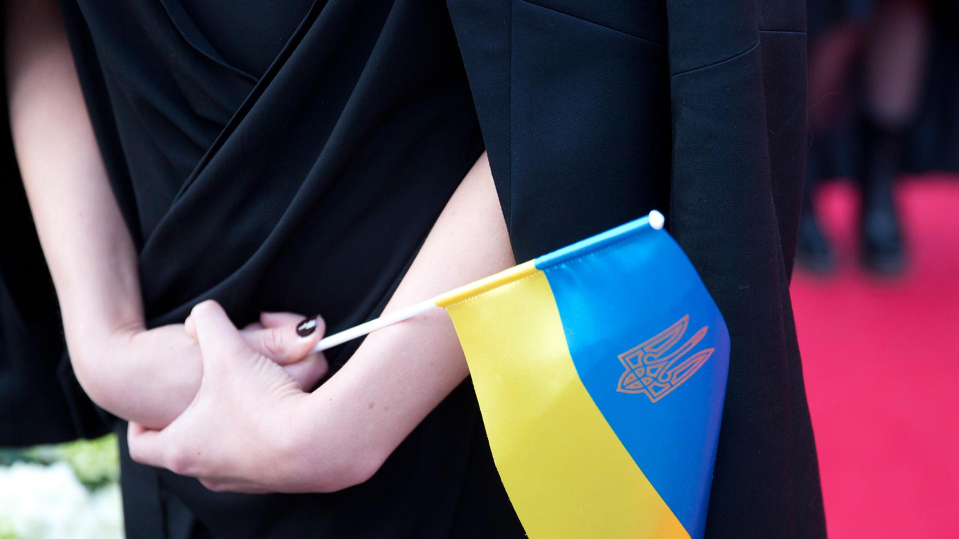 Frau hält eine Ukraine-Fahne in den Händen.