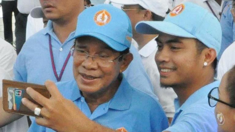 Der kambodschanische Premierminister Hun Sen (vorne links) posiert mit einem Anhänger für ein Selfie in Phnom Penh