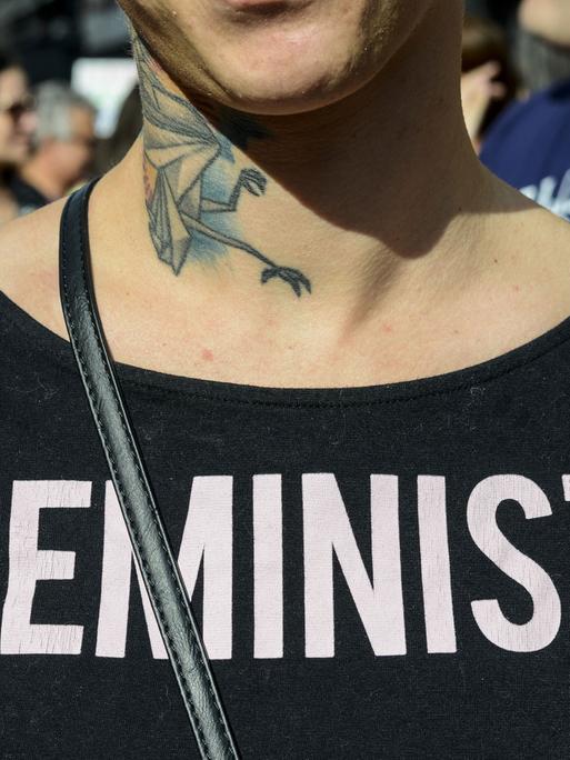 Eine junge Frau trägt ein T-Shirt mit der Aufschriftin "Feministin"