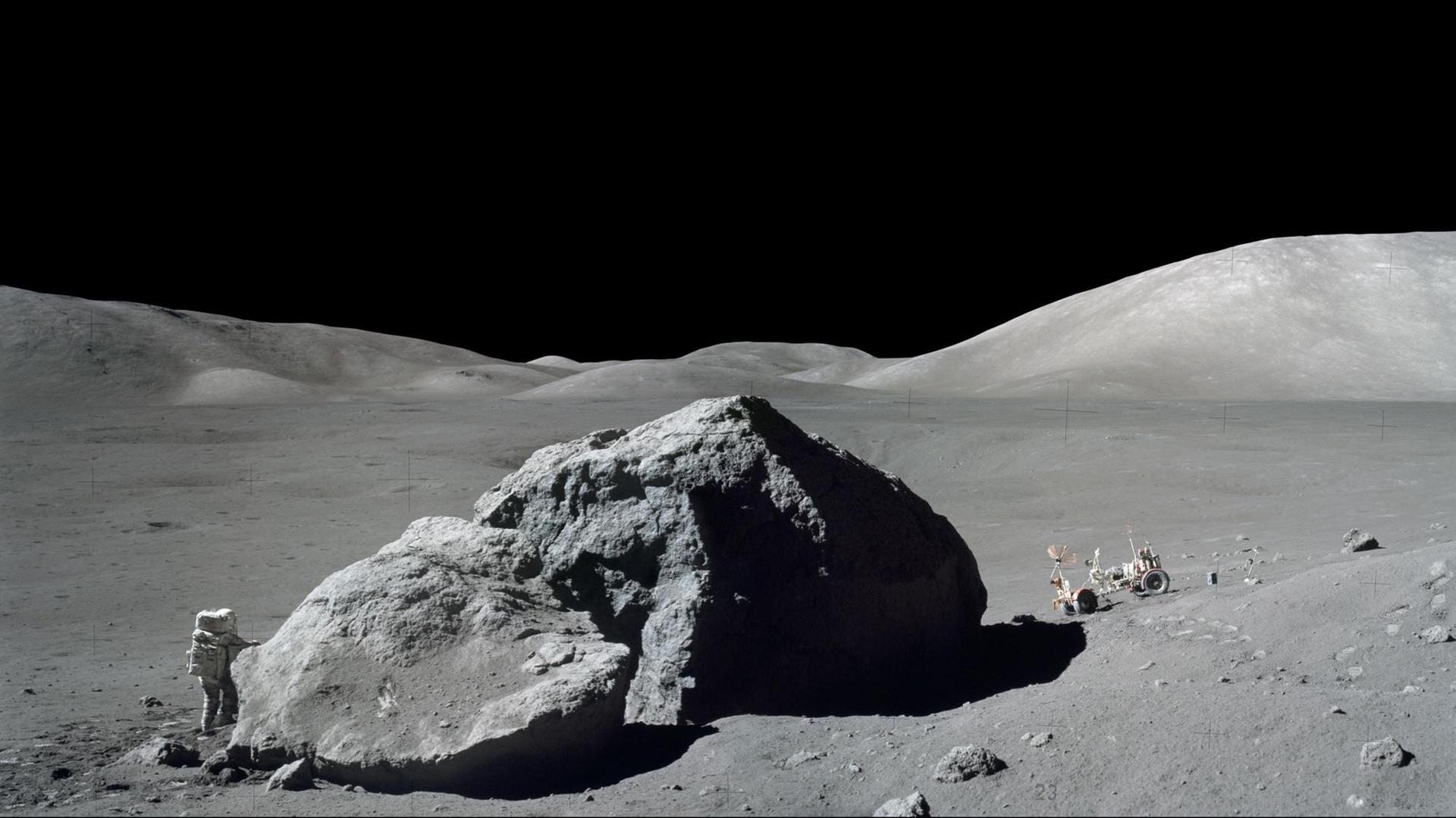 Ein Astronaut neben einem Felsen auf dem Mond