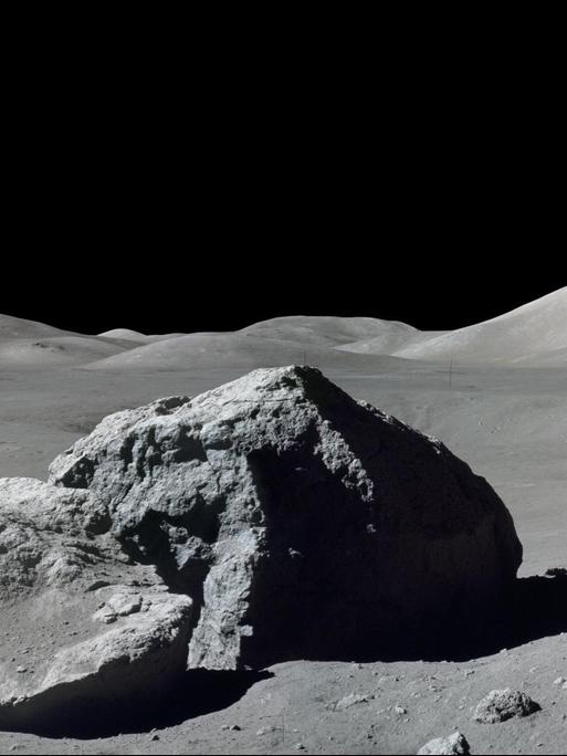 Ein Astronaut neben einem Felsen auf dem Mond