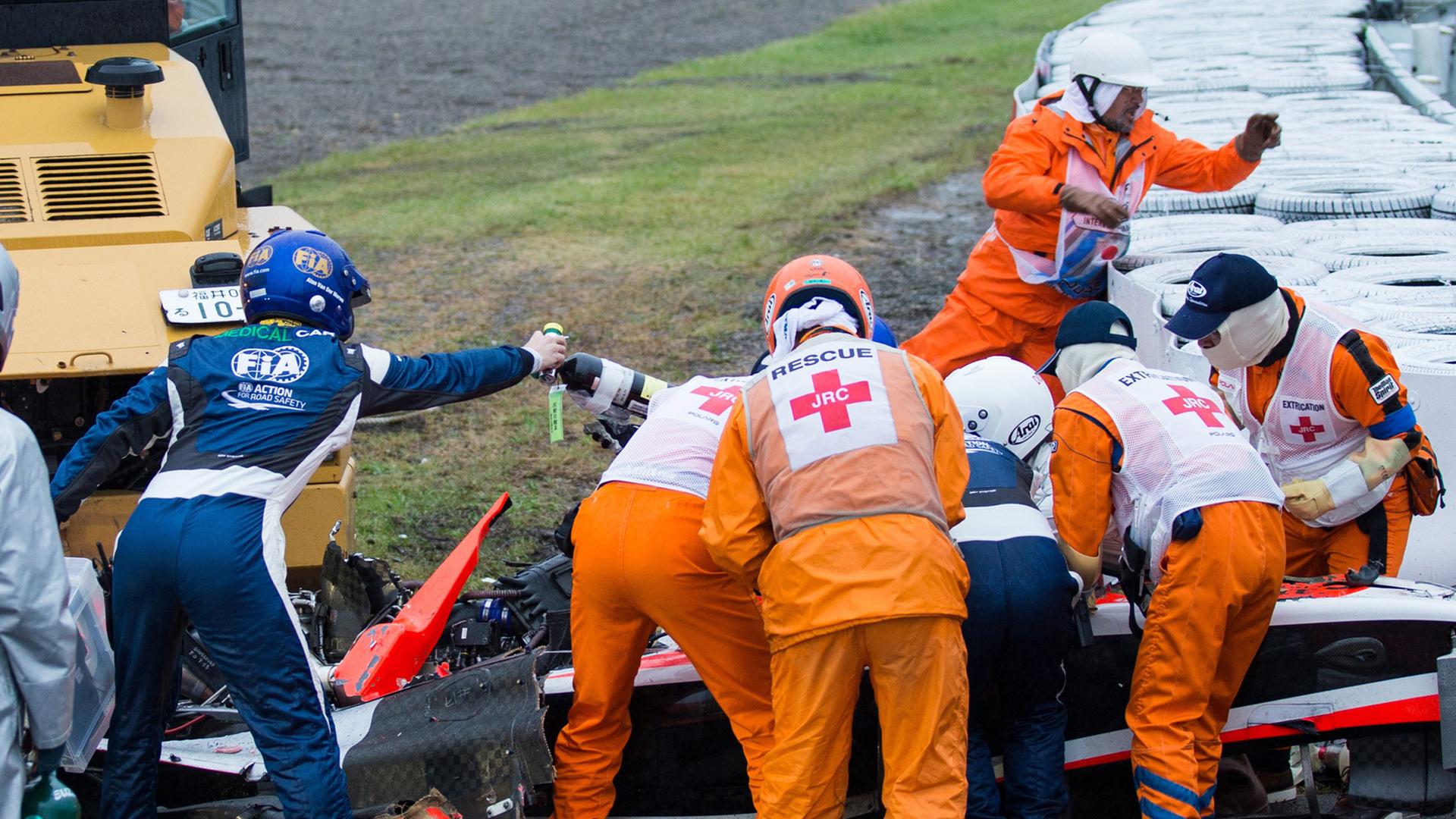 Formel-1-Fahrer Jules Bianchi wurde beim Rennen in Suzuka schwer verletzt. Beim verunglückten Wagen stehen zahlreiche Helfer und Ärzte und leisten erste Hilfe