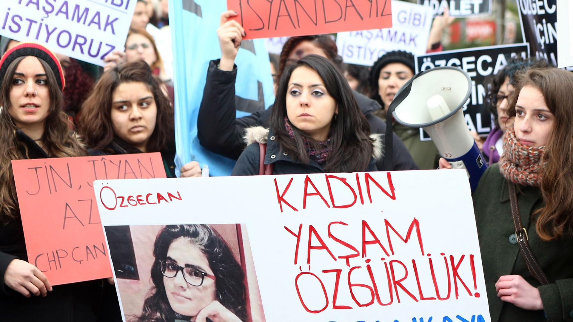 Junge Frauen halten in Ankara Protest-Schilder mit Slogans und einem Foto der ermordeten Frau.