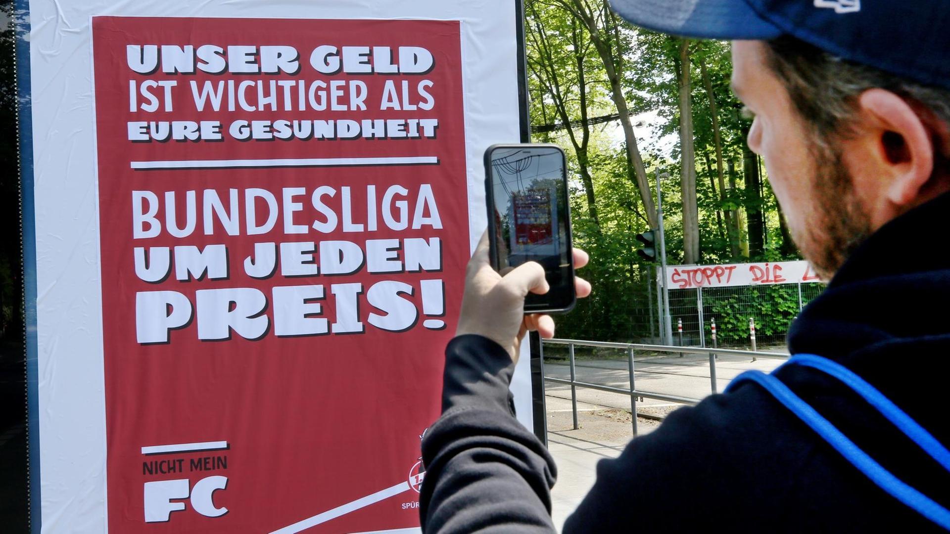 Mann fotografiert Plakat mit der Aufschrift: "Unser Geld ist wichtiger als eure Gesundheit"