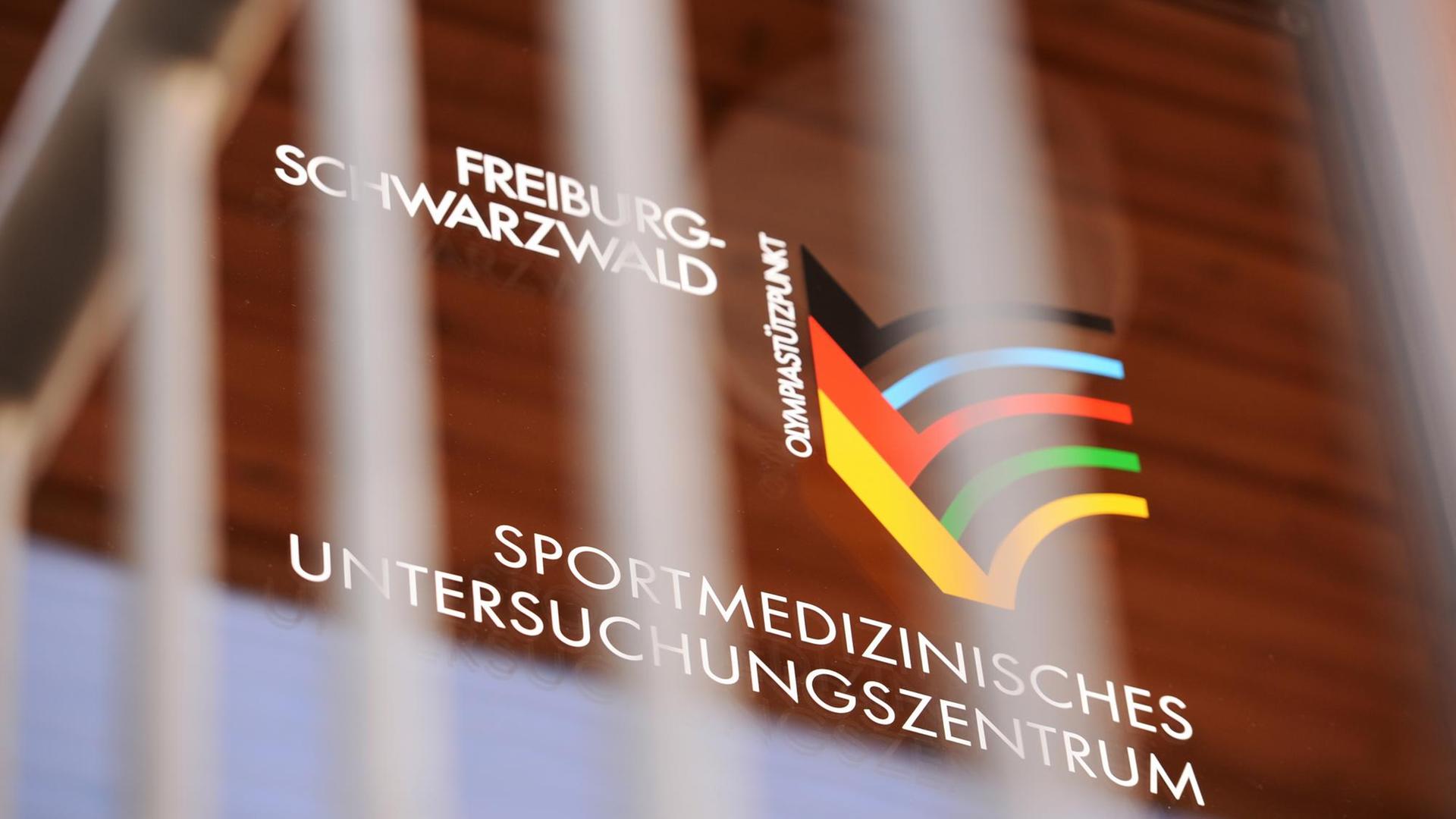 Das Logo des Sportmedizinischen Untersuchungszentrums an der Universitätsklinik in Freiburg am 03.03.2015 an einer Glastür zu sehen.