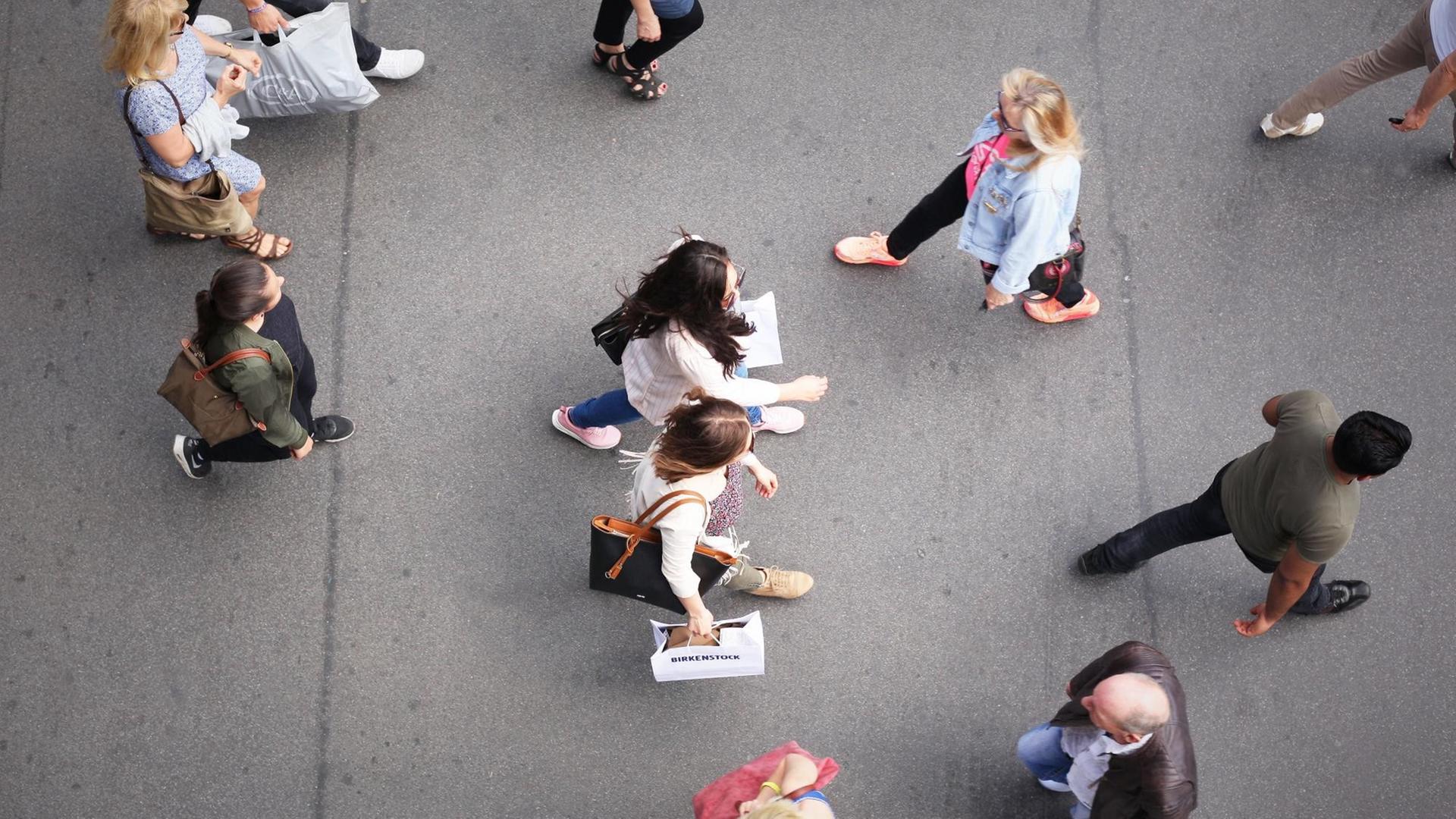 Von oben sind mehrere Menschen auf einer Einkaufsstraße zu sehen, darunter zwei modisch gekleidete, junge Frauen mit Einkaufstüten in der Hand - aufgenommen am 26.05.2017 in Berlin im Stadtteil Steglitz.