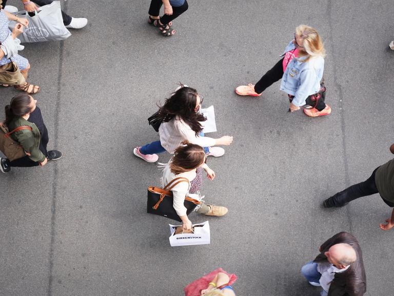 Von oben sind mehrere Menschen auf einer Einkaufsstraße zu sehen, darunter zwei modisch gekleidete, junge Frauen mit Einkaufstüten in der Hand - aufgenommen am 26.05.2017 in Berlin im Stadtteil Steglitz.