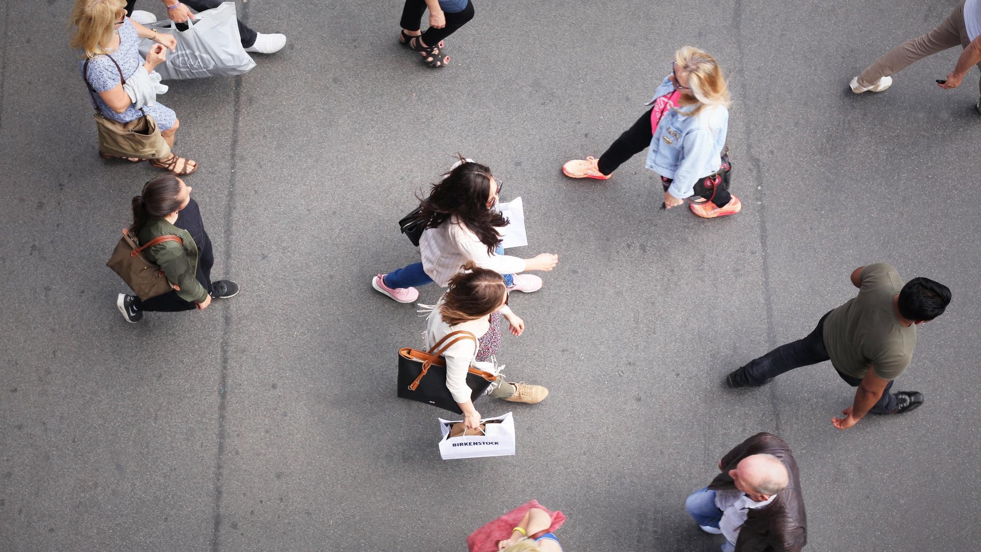 Von oben sind mehrere Menschen auf einer Einkaufsstraße zu sehen, darunter zwei modisch gekleidete, junge Frauen mit Einkaufstüten in der Hand - aufgenommen am 26.05.2017 in Berlin im Stadtteil Steglitz.