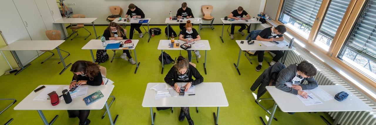 Abiturienten am Gymnasium Dresden Klotzsche sitzen in einem Klassenzimmer für Prüfungsvorbereitungen.