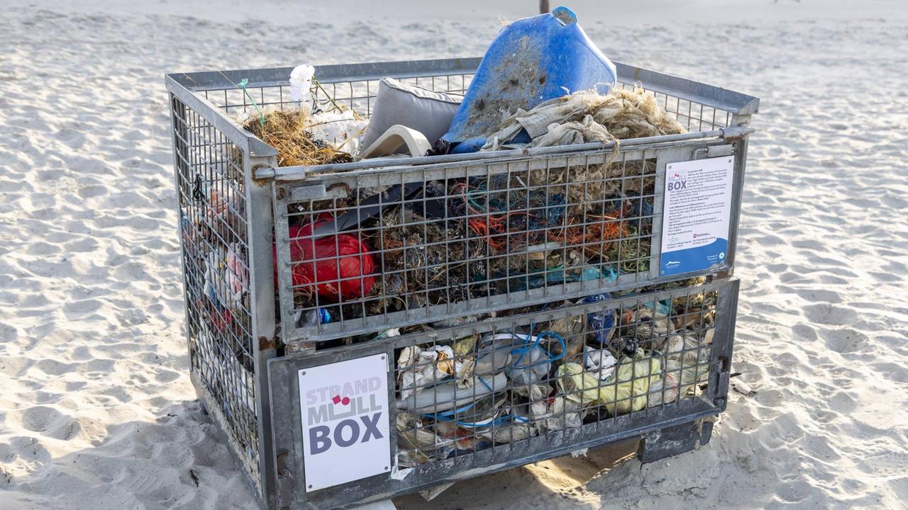 Eine Gitterbox am Strand für aufgesammelten Müll.