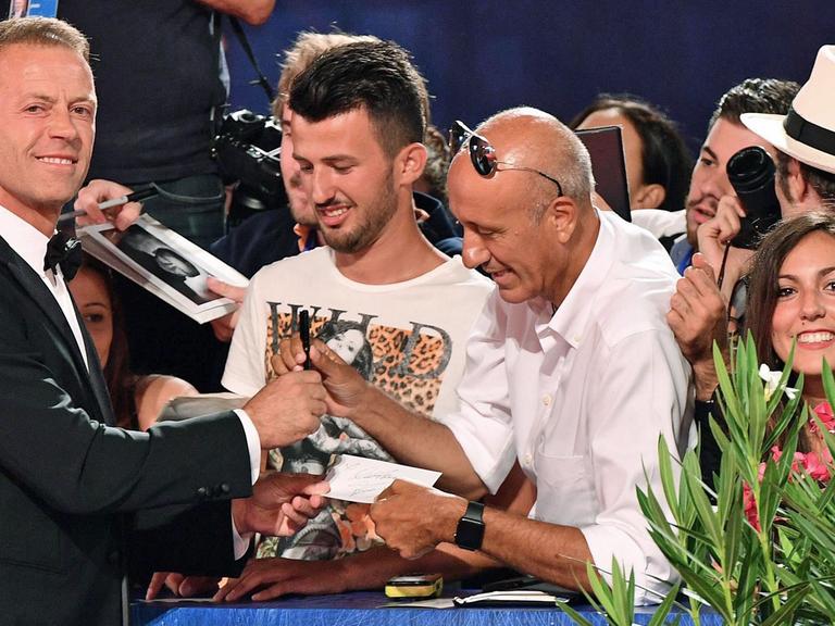 Der italienische Schauspieler und Pornodarsteller Rocco Siffredi (l) gibt bei der Premiere des Dokumentarfilms "Rocco" am 5.9.2016 bei den 73. Internationalen Filmfestspielen in Venedig Autogramme.