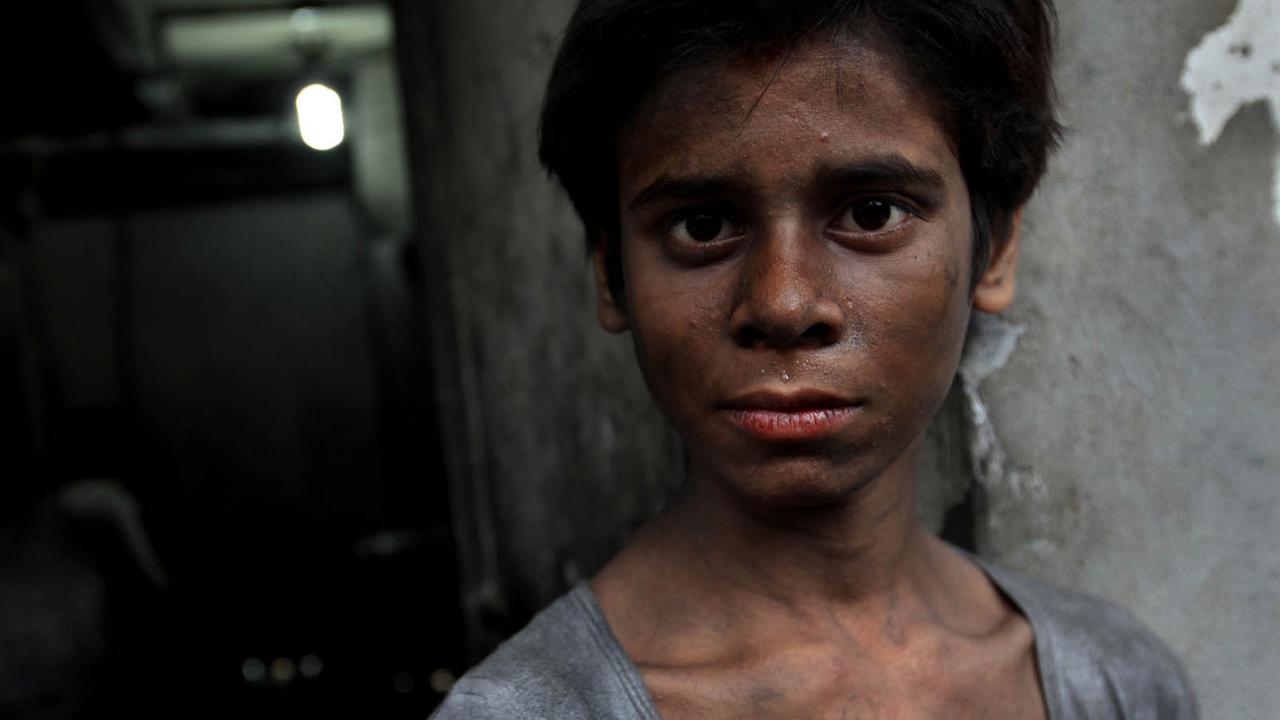 Ein Kind in der indischen Stadt Kalkutta nach Ende seiner Schicht in einer Stahlfabrik