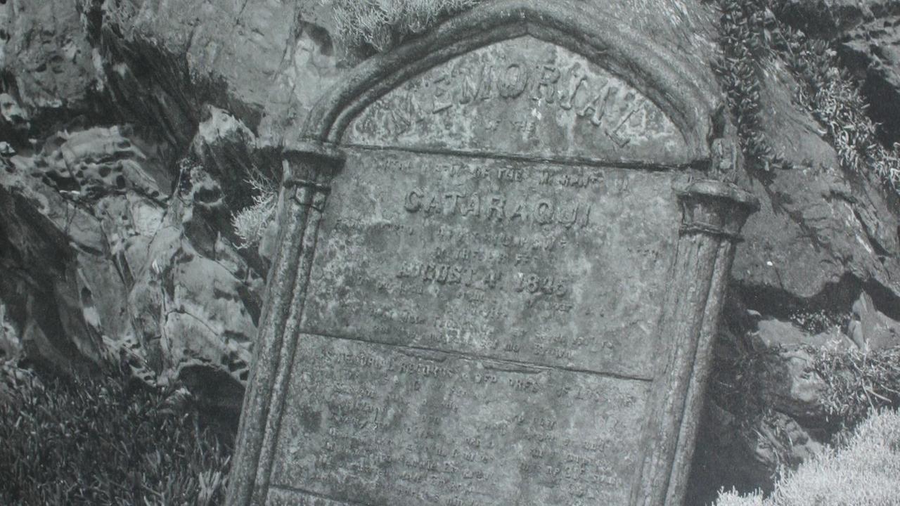 Das schwarz-weiße Foto zeigt eine Gedenktafel, die schon stark von Meersalz beschädigt ist