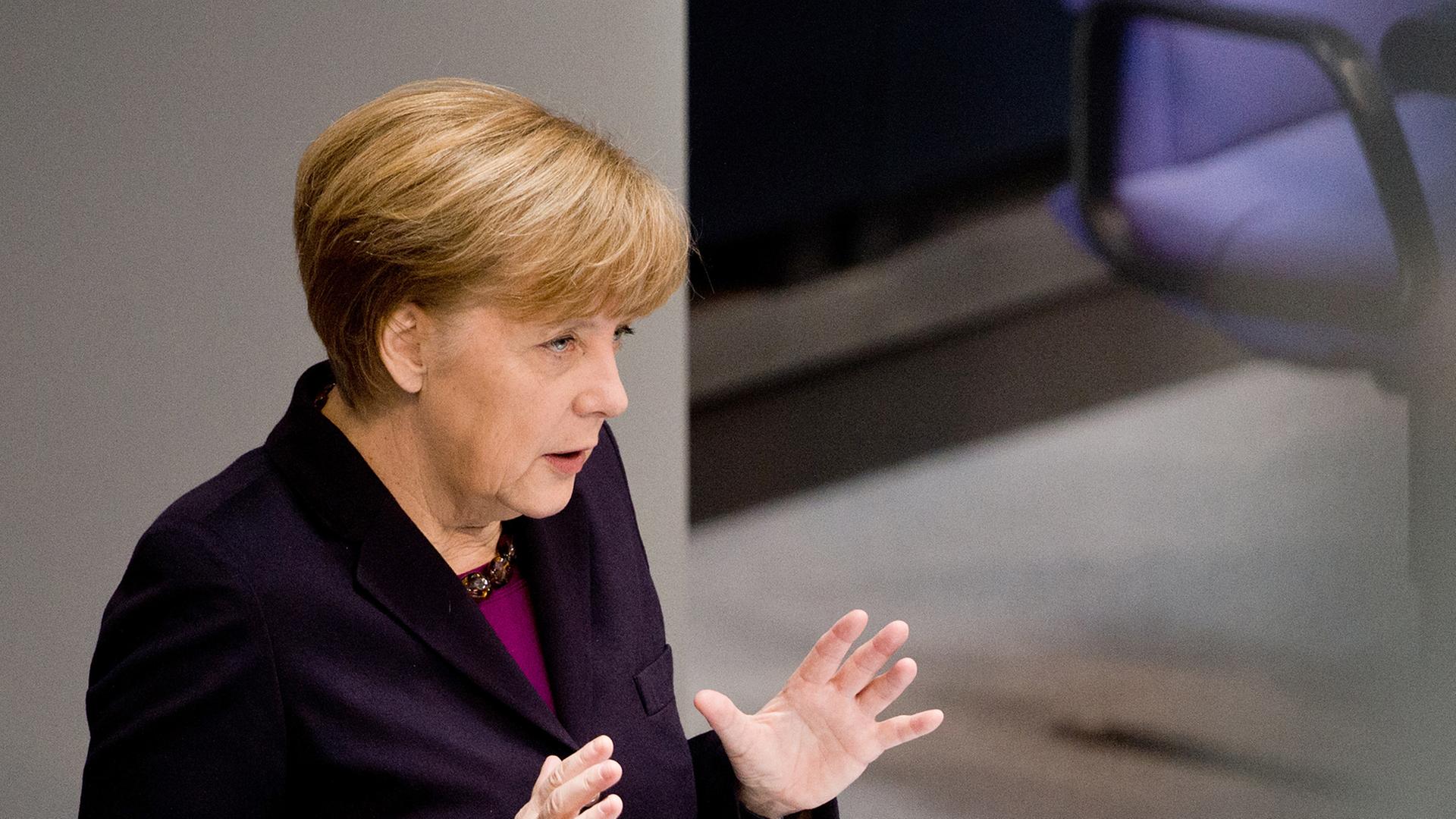 Bundeskanzlerin Angela Merkel (CDU) hält während ihrer Regierungserklärung am 20.03.2014 im Bundestag beide Hände in die Höhe.