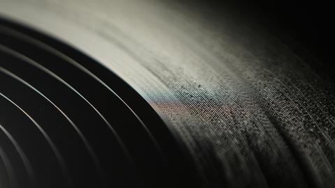 Man sieht einen Bildausschnitt einer Vinylplatte auf einem Plattenteller.