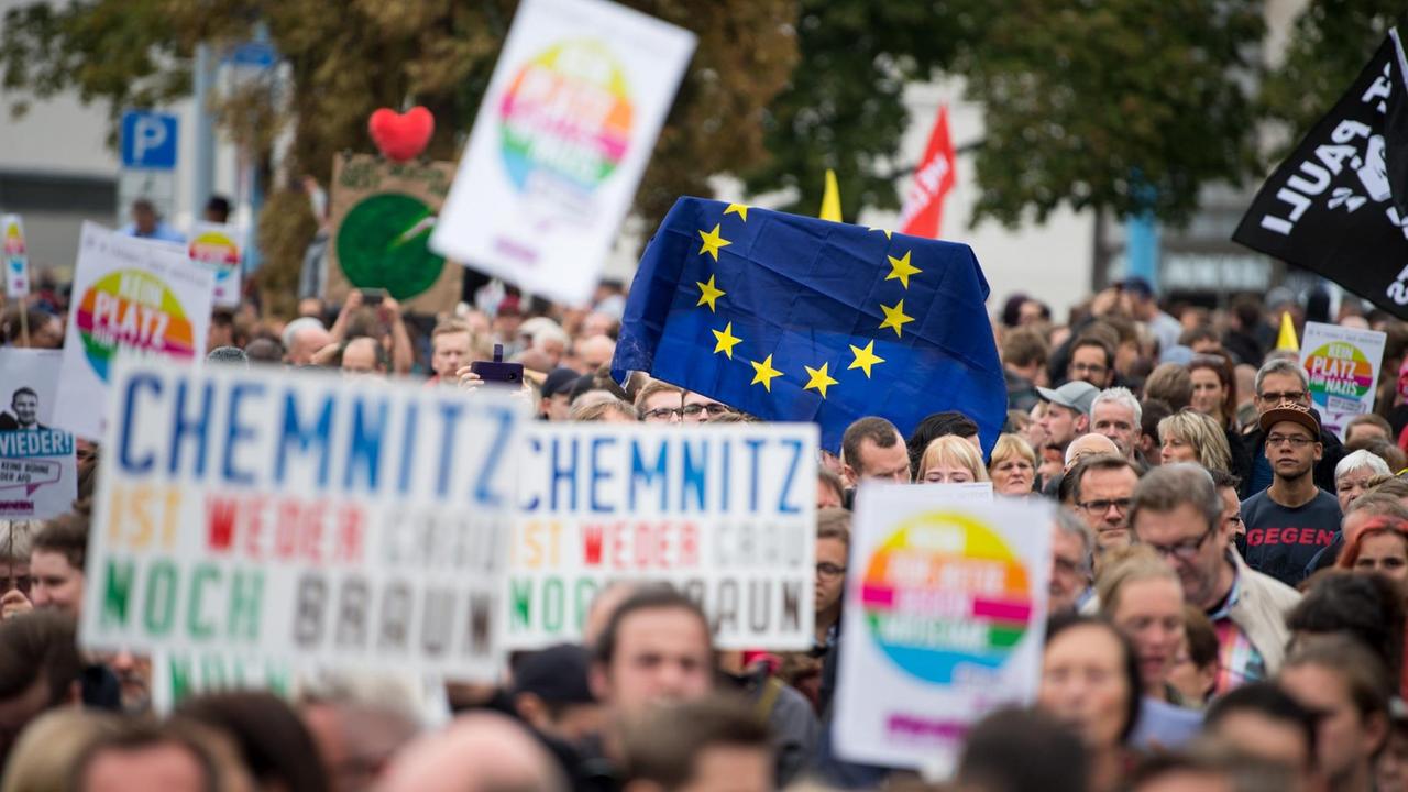 Teilnehmer der Kundgebung des Bündnisses "Chemnitz Nazifrei", am 1. September 2018, halten Schilder und eine Flagge der EU hoch.