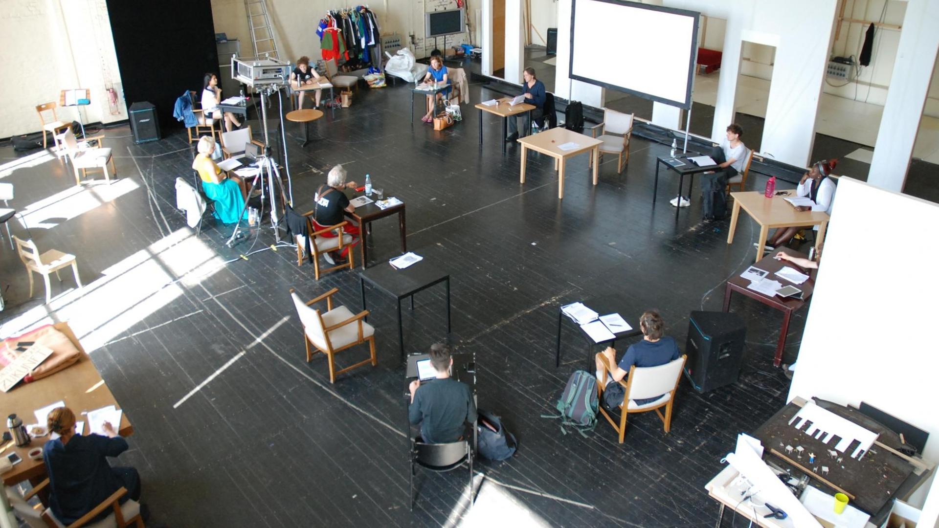 Leseprobe im Bochumer Schauspielhaus: Schauspieler und Regisseur sitzen in einem großen Kreis im Probensaal und halten wegen der Coronapandemie Abstand.