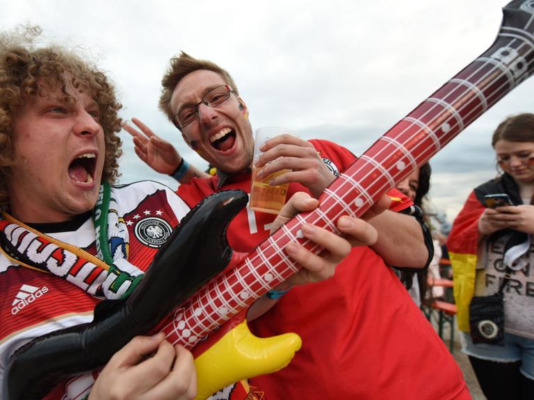 Fußballfans jubeln am 12.06.2016 beim Public Viewing auf dem Messegelände in Freiburg (Baden-Württemberg) vor der Fußball-EM-Begegnung Deutschland vs. Ukraine. Foto: Patrick Seeger/dpa