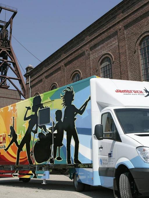 Bunt bemalter Truck mit Musikern einer Band vor der Essener Zollverein