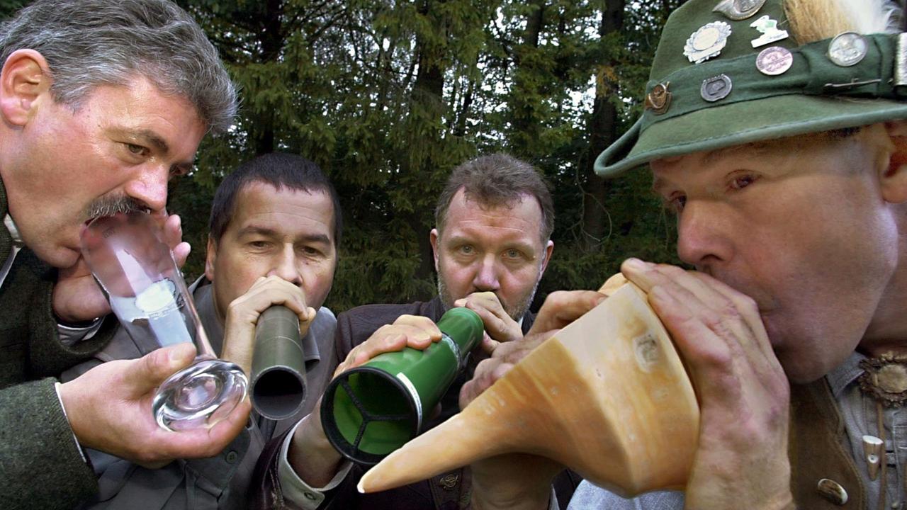 Mit einem Bierglas, einem Plastik- und einem Resonanzrohr sowie einer tibetanischen Gebetsmuschel ahmen vier Männer einen Hirschruf nach.