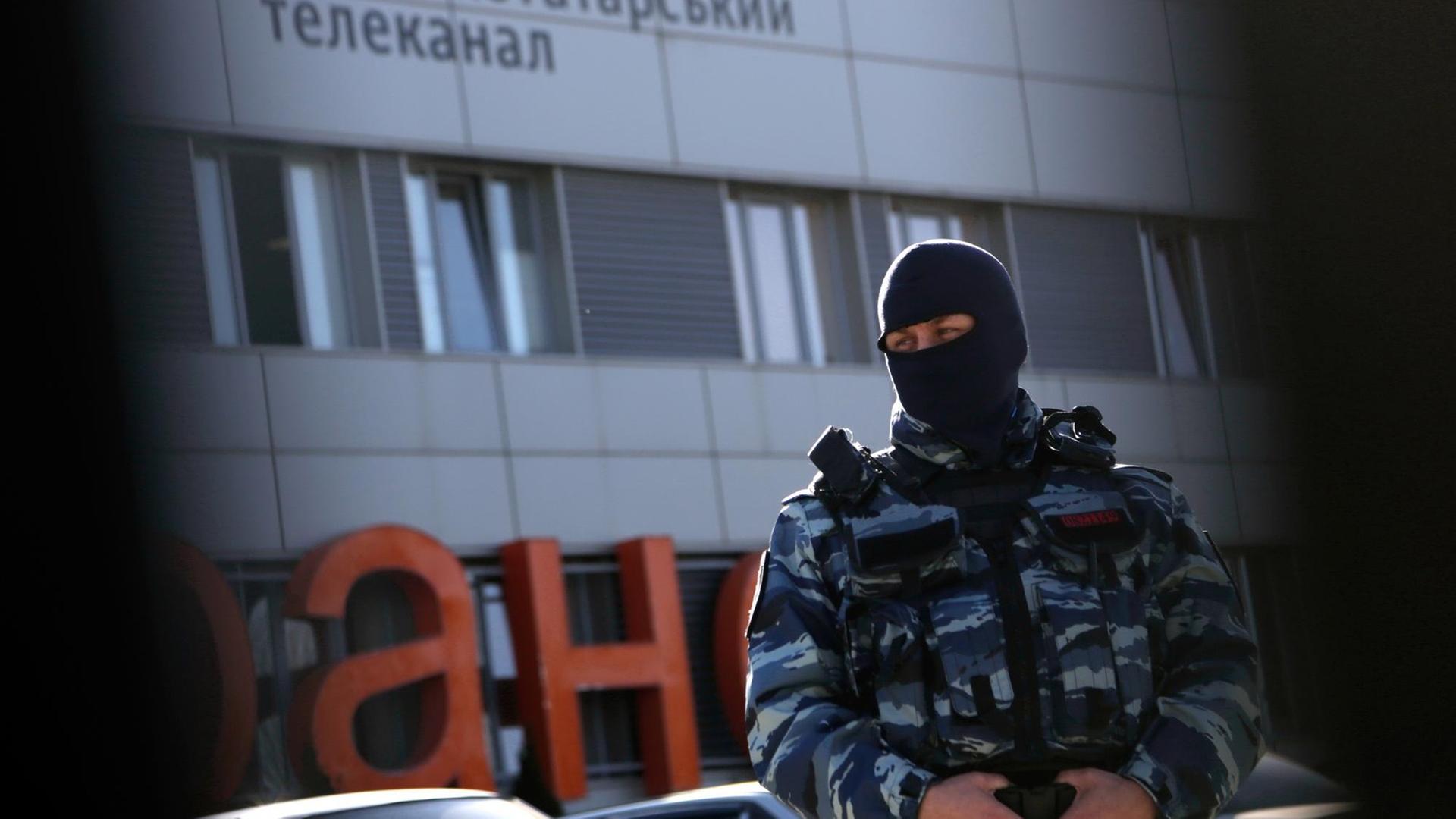 Ein Offizier der russischen Polizei steht am 26. Januar 2015 vor dem Gebäude des Krimtataren-Senders ATR in Simferopol Wache. Die russische Staatsmacht hat eine Verlängerung der Sendelizenz verweigert. Von Kiew aus versucht nun ein kleines Team von ATR-Journalisten einen Neustart, nachdem ATR eine Sendelizenz vom ukrainischen Staat bekommen hat.