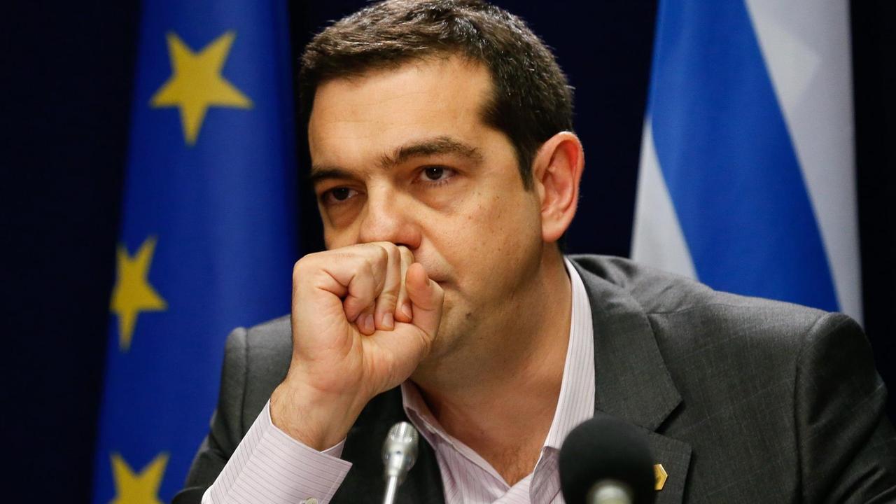 Alexis Tsipras blickt nachdenklich, er hält die geballte Hand vor seinen Mund.