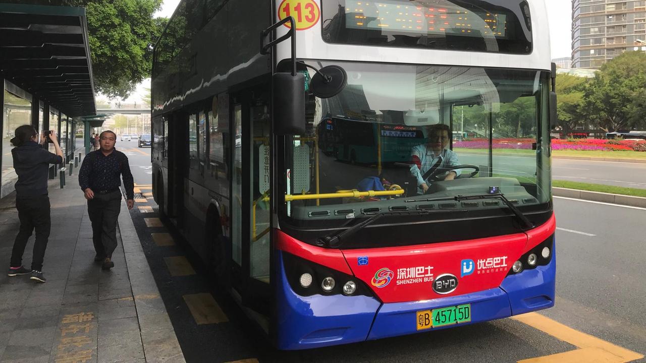 Ein Elektrobus hält in Shenzhen / China an einer Bushaltestelle.