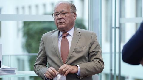 Wolfgang Ischinger hält eine Maske in der Hand.