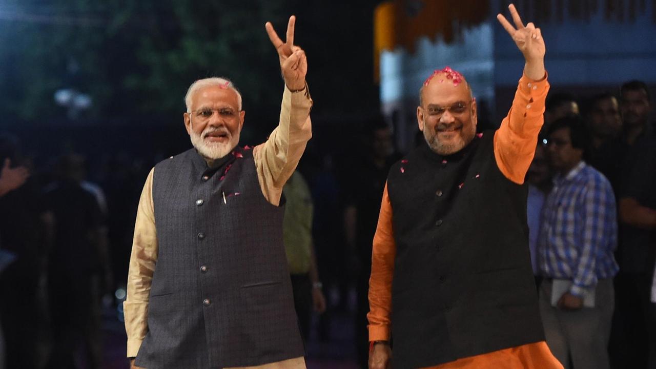 Premierminister Narendra Modi (L) und der Präsident der regierenden Bharatiya Janata Partei zeigen das Victory-Zeichen.