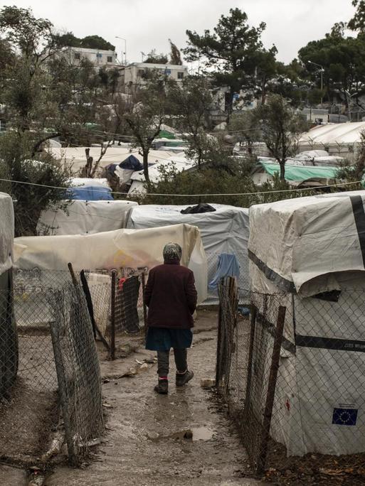 Eine Migrantin steht im Regen, im Moria Lager auf Lesbos