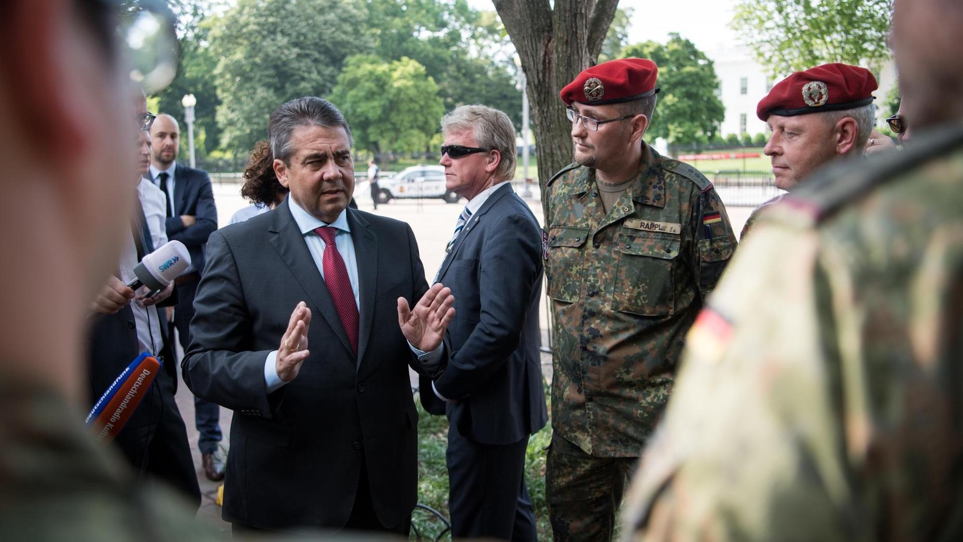 Außenminister Sigmar Gabriel (SPD) unterhält sich am 18.05.2017 vor dem Weißen Haus in Washington, D.C. (USA) nach seinem Treffen mit dem Nationalen Sicherheitsberater des US-Präsidenten, McMaster, mit deutschen Soldaten, die zu einer Weiterbildung in Washington sind. Der deutsche Außenminister Gabriel ist zu einem zweitägigen Besuch in den Vereinigten Staaten von Amerika und besucht anschließend Mexiko. Foto: Bernd von Jutrczenka/dpa | Verwendung weltweit