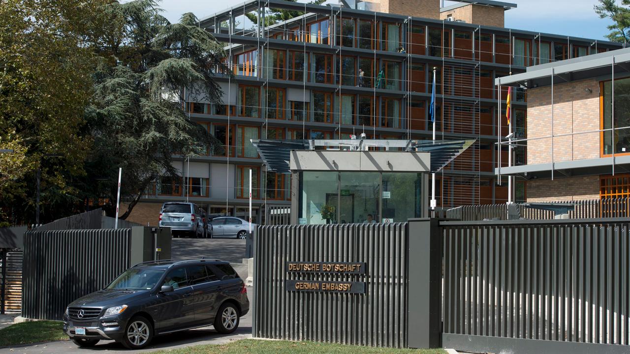 Durch die Toreinfahrt der Deutschen Boschaft in Washington fährt ein dunkler SUV.