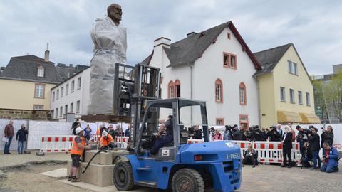 Die größtenteils mit einer Plane verdeckte 2,3 Tonnen schwere und 4,40 Meter große Karl-Marx-Statue des chinesischen Künstlers Wu Weishan wird in Trier aufgestellt.