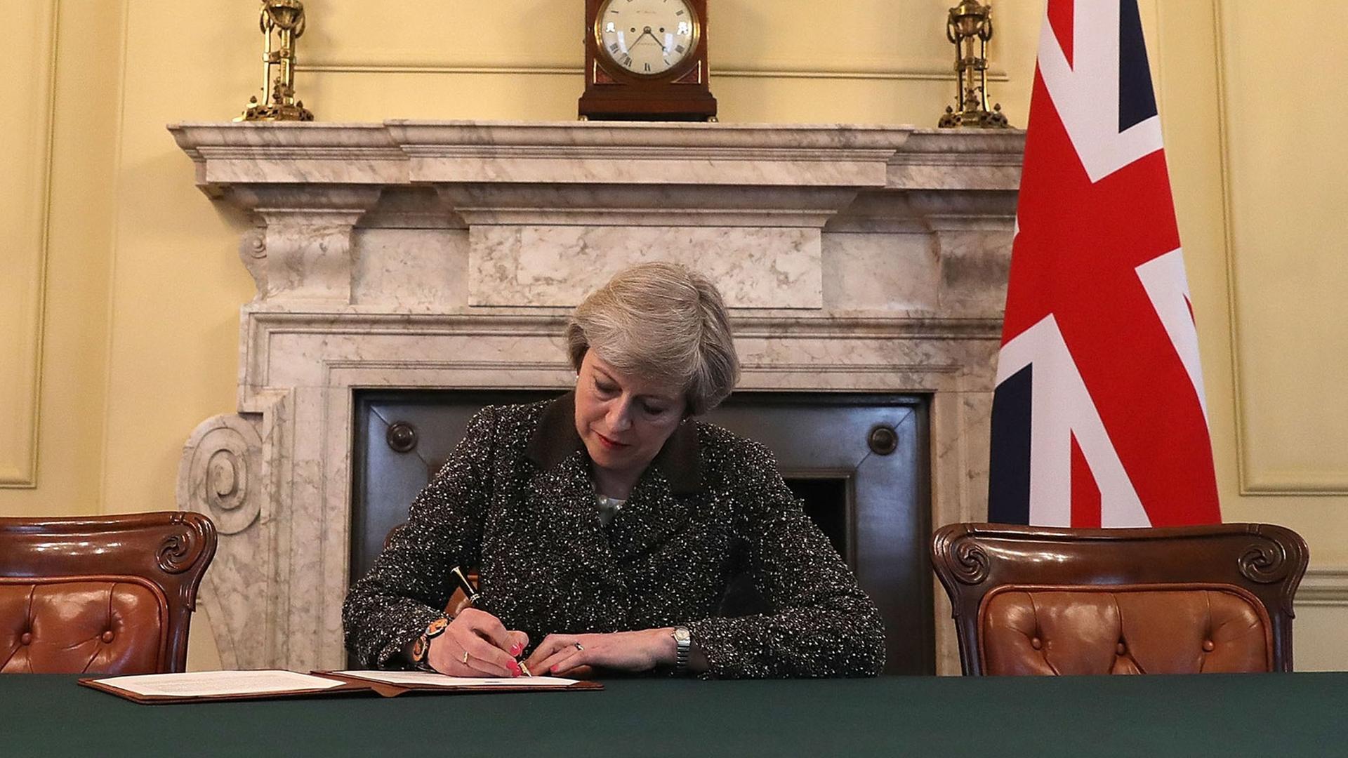 Das Bild zeigt die britische Premierministerin May während der Unterschrift unter den EU-Austrittsantrag ihres Landes.