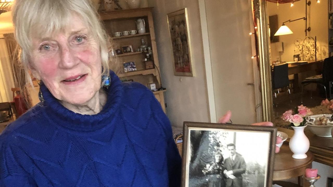 Die niederländische Historikerin Monika Diederichs hält in ihrem Wohnzimmer in Haarlem eine gerahmte Schwarz-Weiß-Fotografie ihrer Eltern in der Hand