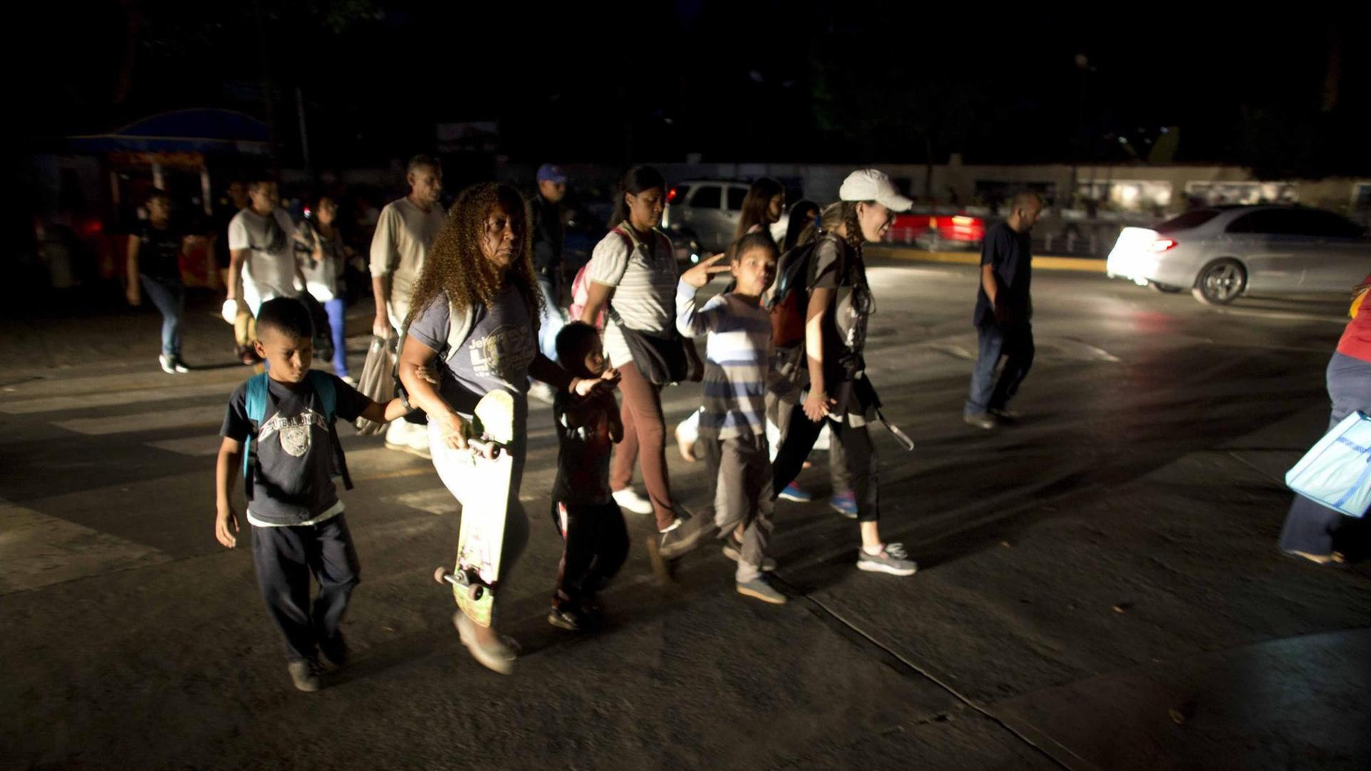 Nach dem landesweiten Stromausfall: Menschen laufen durch die dunklen Straßen von Caracas.