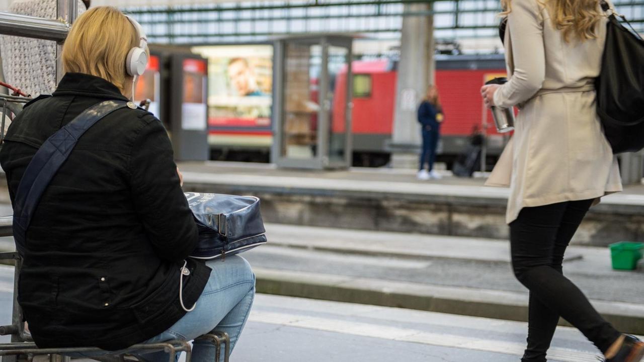 Eine Reisende sitzt am 20.05.2015 im Hauptbahnhof in Stuttgart (Baden-Württemberg) auf einem Kofferkuli, da alle Sitzbänke belegt sind. Die Lokführer streiken erneut.