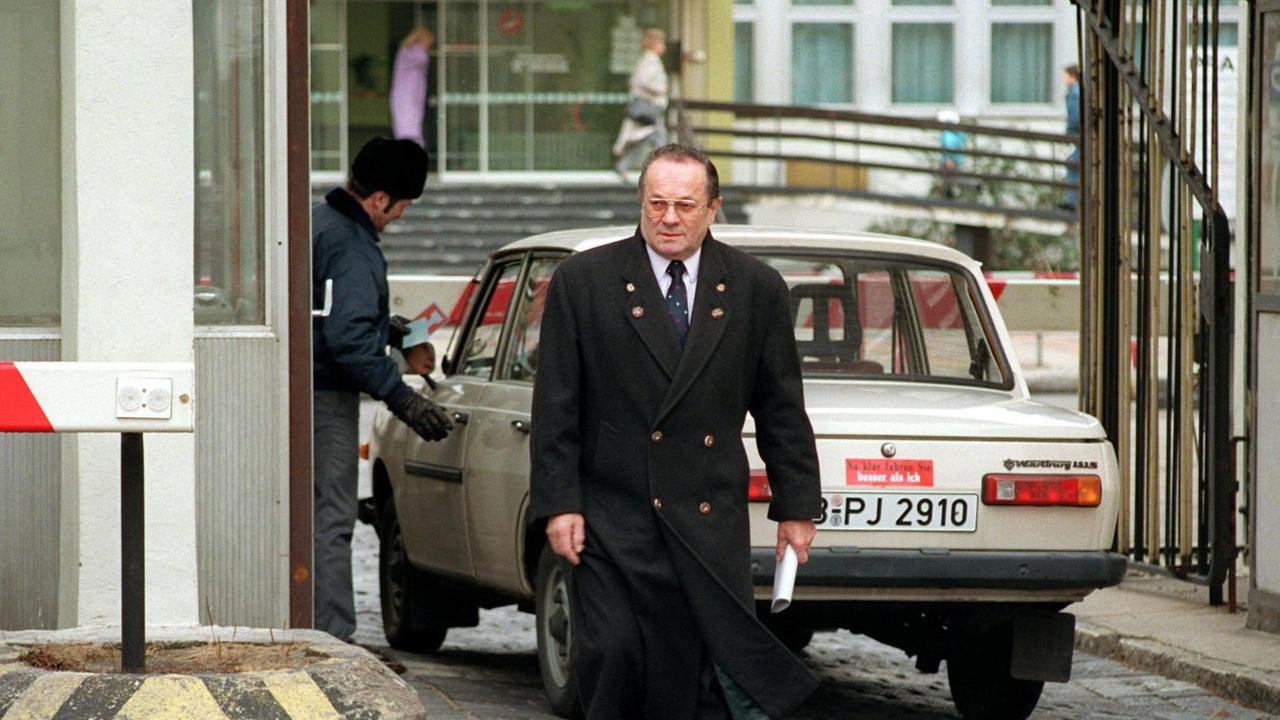Der Rundfunkbeauftragte Rudolf Mühlfenzl kommt am 30.12.1991 vom Gelände des Deutschen Fernsehfunks in Berlin-Adlershof. Ein Mann im Mantel kommt aus einem Eingangstor. 