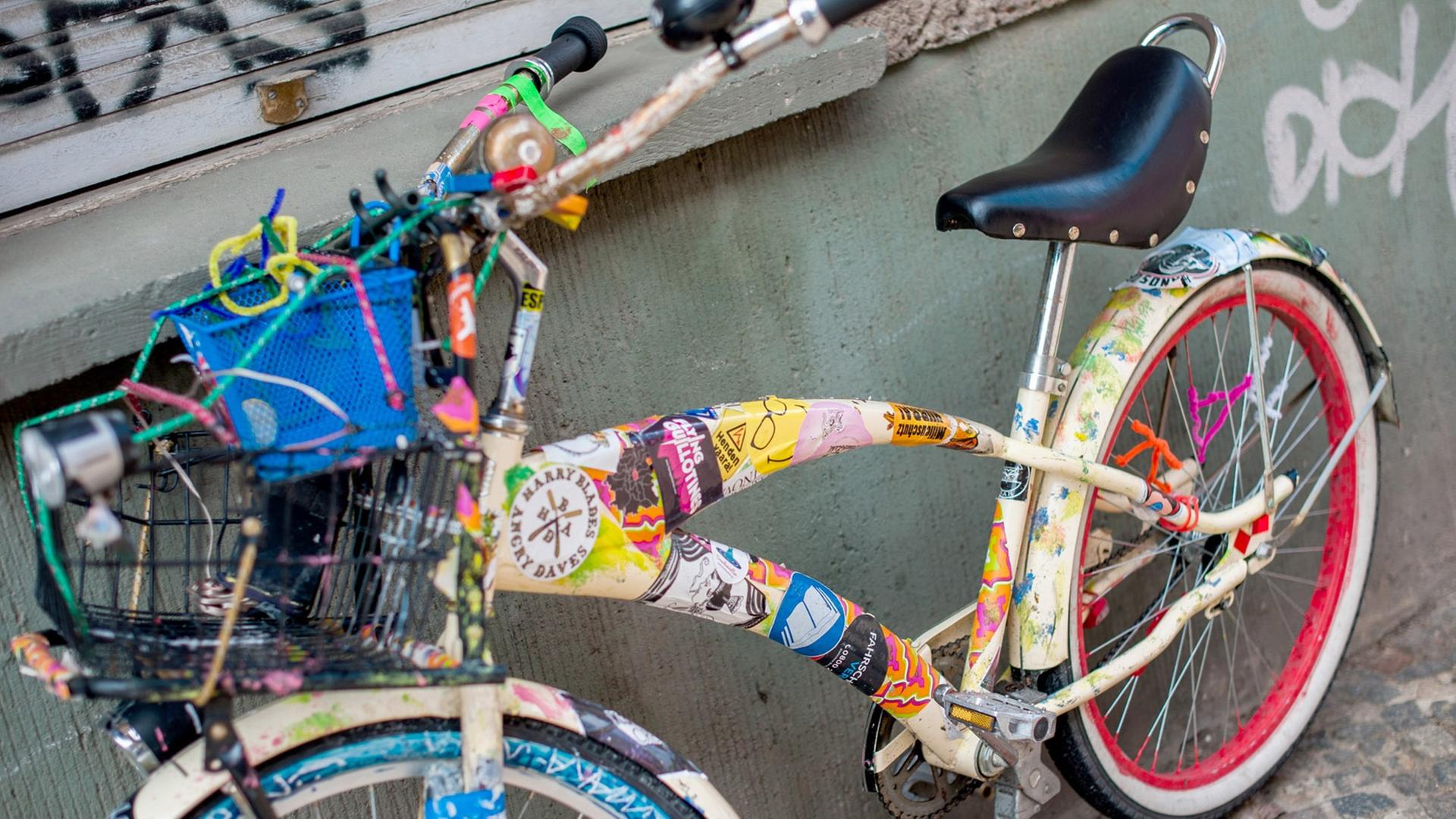 Ein mit Aufklebern versehenes Fahrrad steht in einer Straße im Stadtteil Prenzlauer Berg in Berlin.