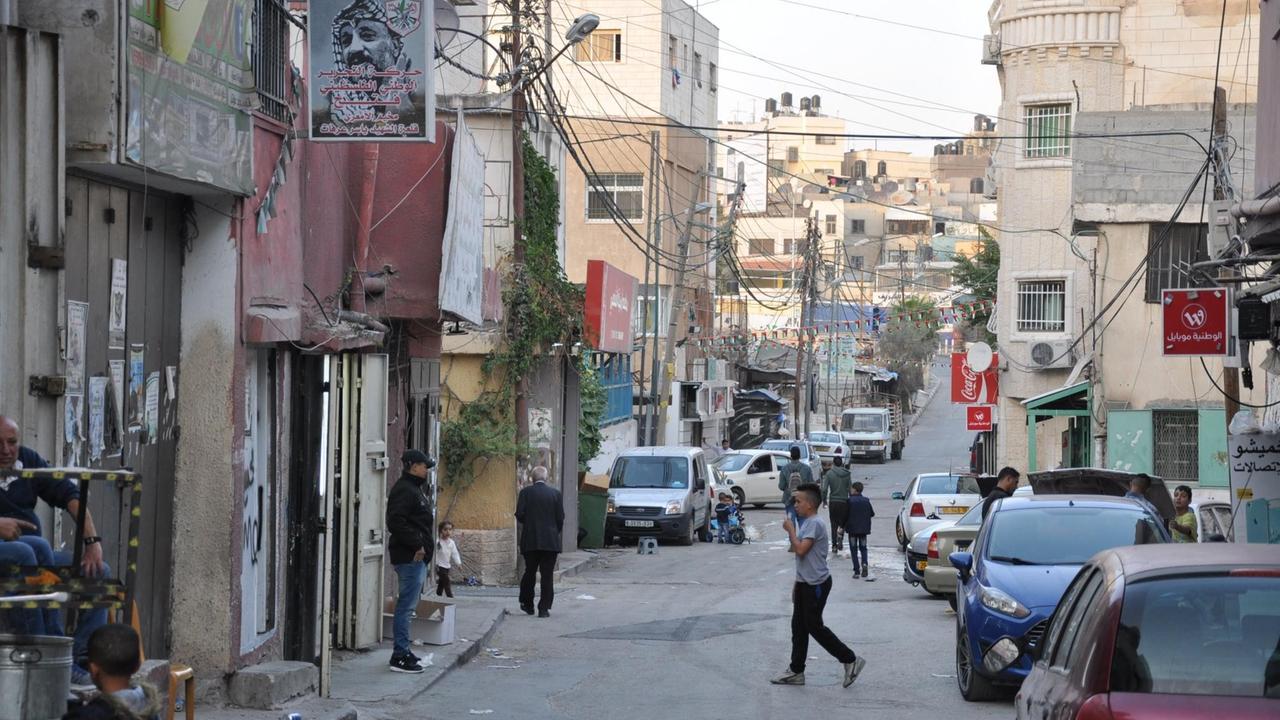 Al-Amari ist ein Flüchtlingslager für Palästinenser, das sich zur Stadt entwickelt hat. Straßen und marode Häuser sind zu sehen.
